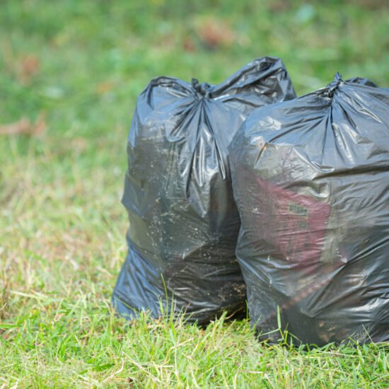 two black garbage bags put on grass floor